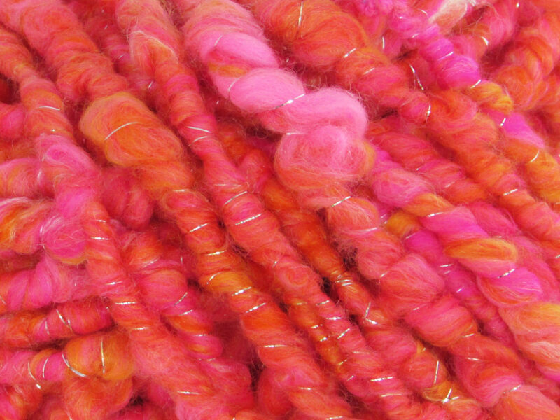 Close up of bright orange and pink Fruit Salads corespun hand spun yarn