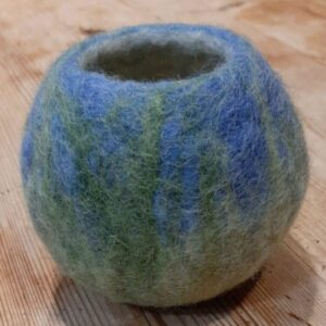 A small light blue felt bowl with decorative green details to suggest plants