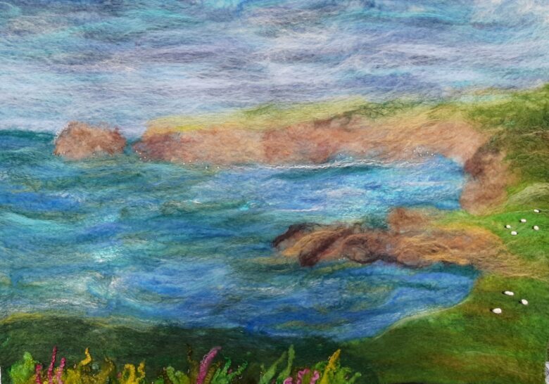 example of a felted seascape showing cliffs and grazing sheep for the felting workshops in North Cornwall