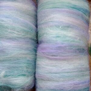 Two batts of carded green, lilac and white merino and corriedale fibre side by side.
