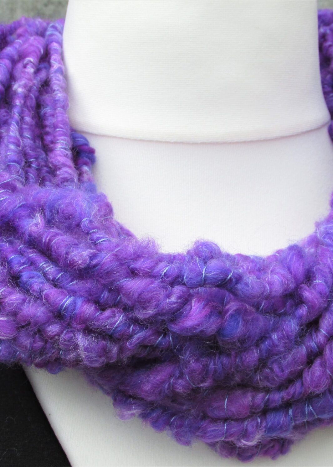 Close up of bluey purple hand spun yarn cowl on a tailor's dummy.