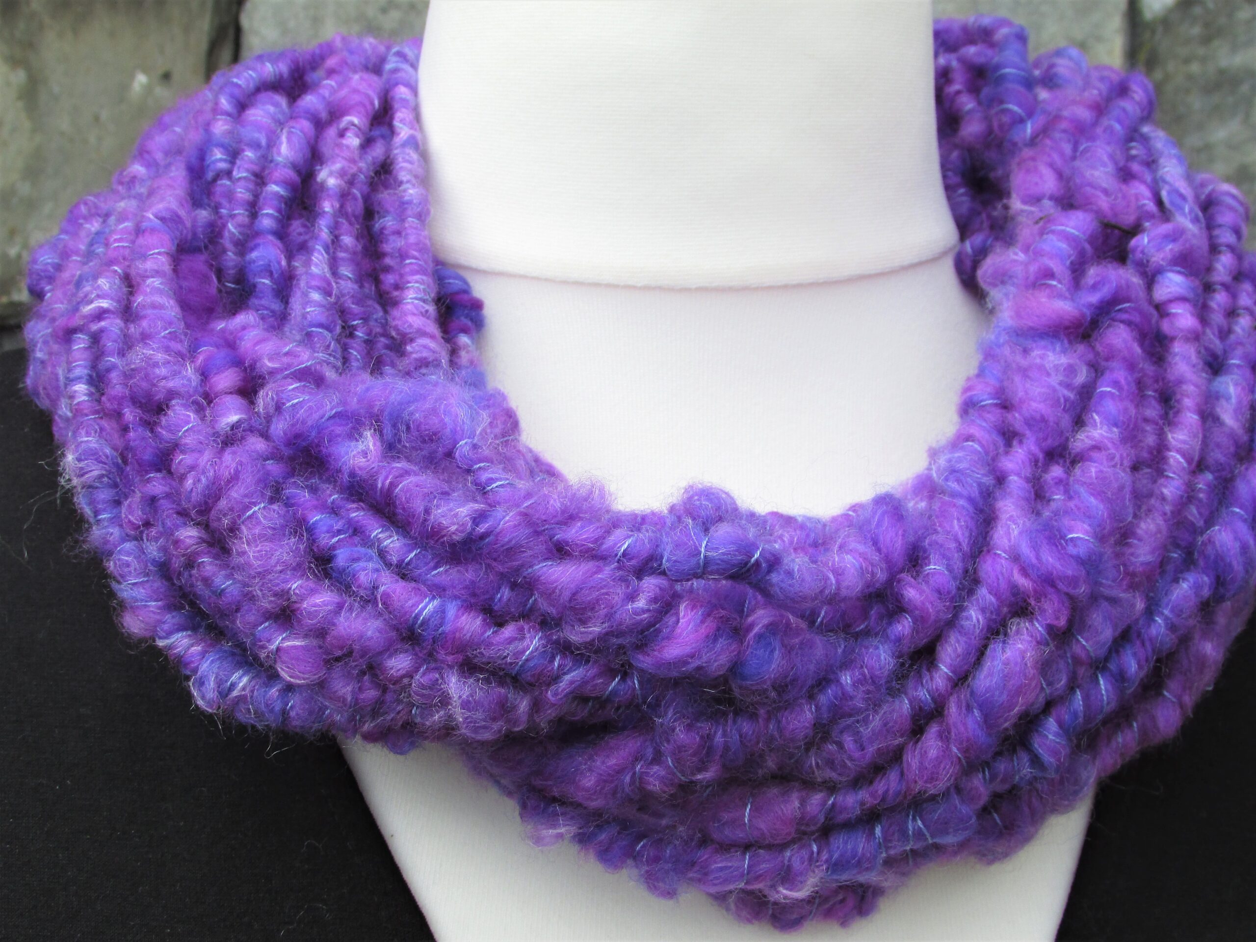 Close up of bluey purple hand spun yarn cowl on a tailor's dummy.