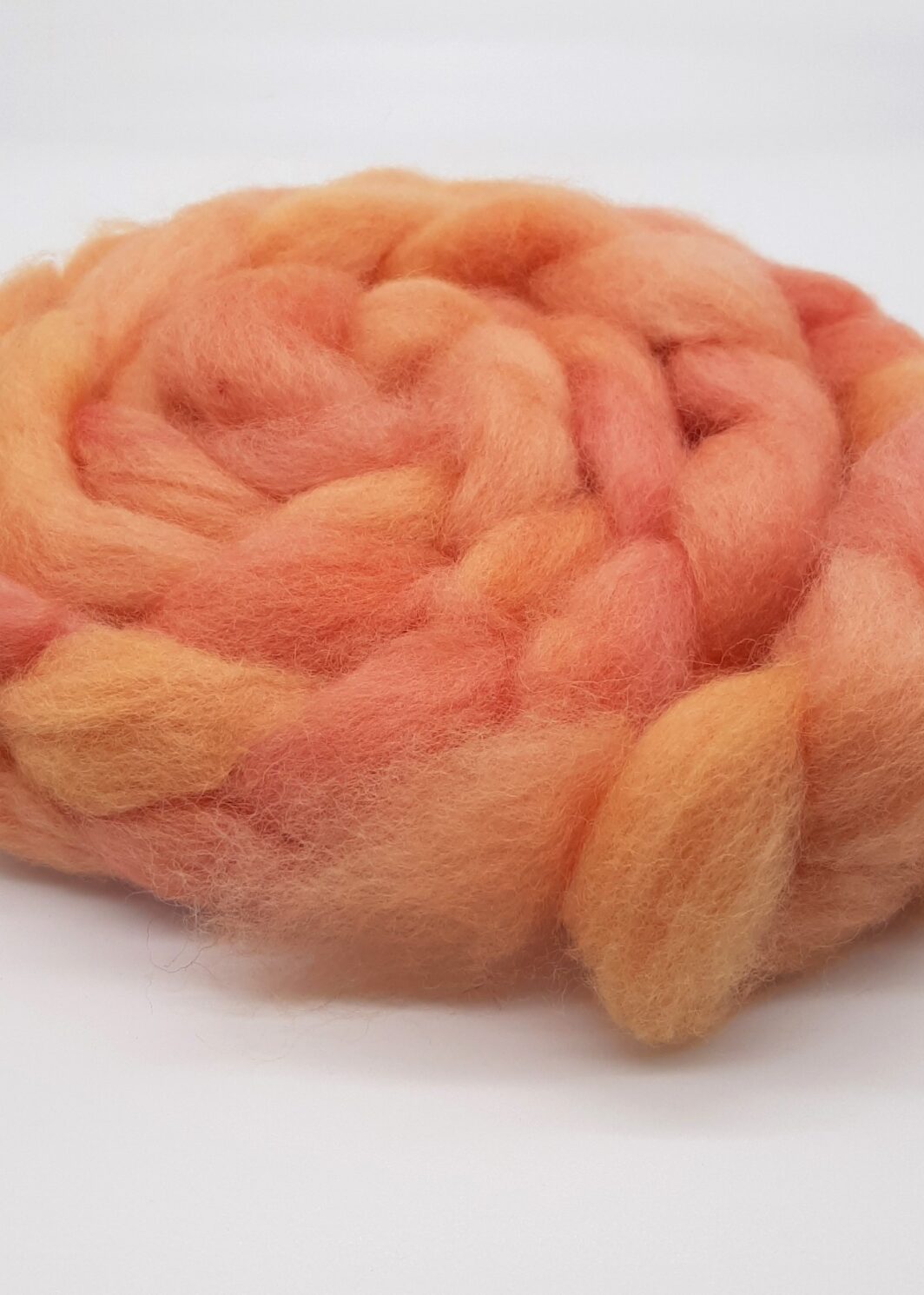 A braid of Cornish hand dyed Romney roving in shades of orange.