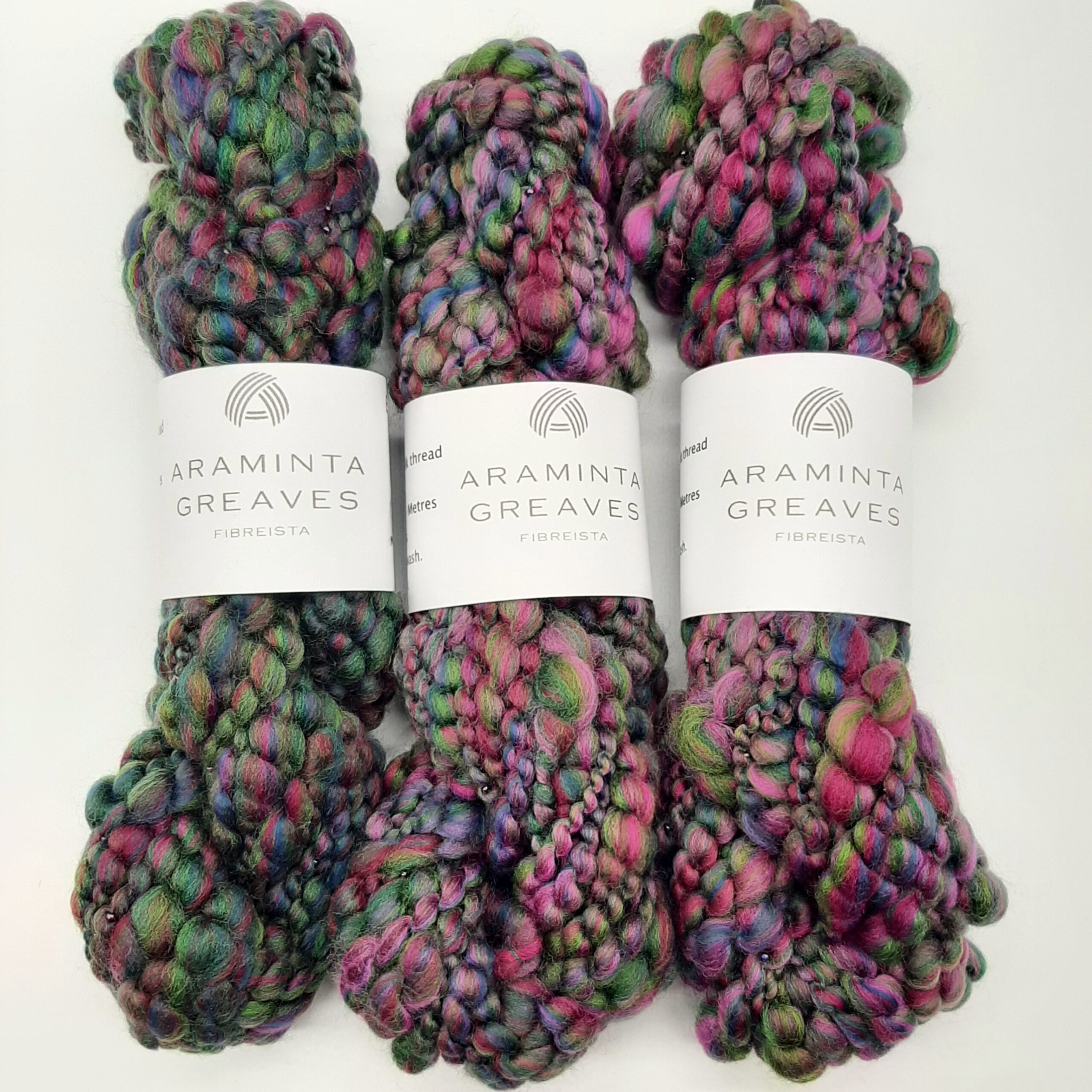 Three skeins of Evening Heather handspun merino beaded yarn in deep, rich heather colours.