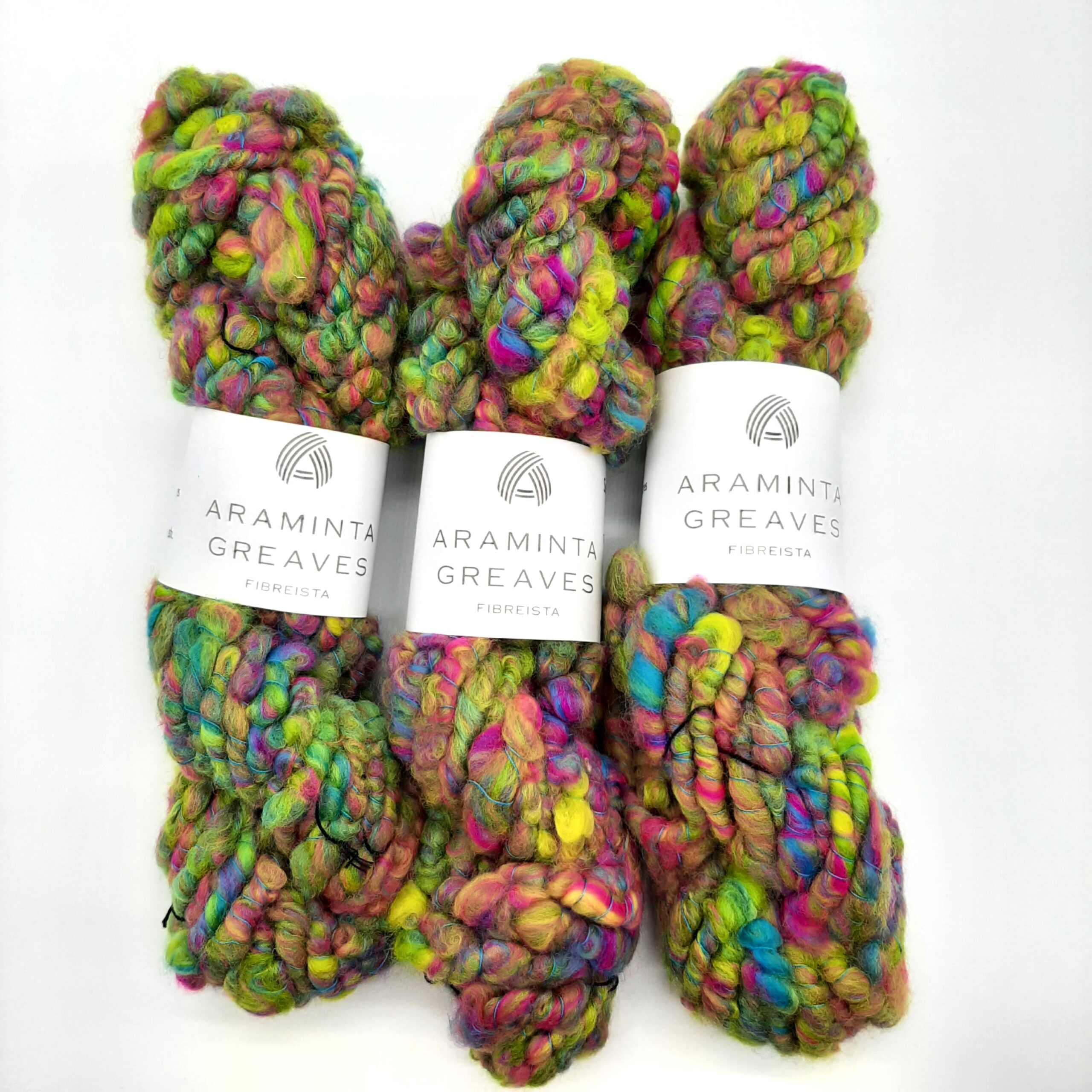 Three skeins of Summerleaze Beach Huts hand spun corespun merino yarn in vibrant yellow, pink, green and blue.