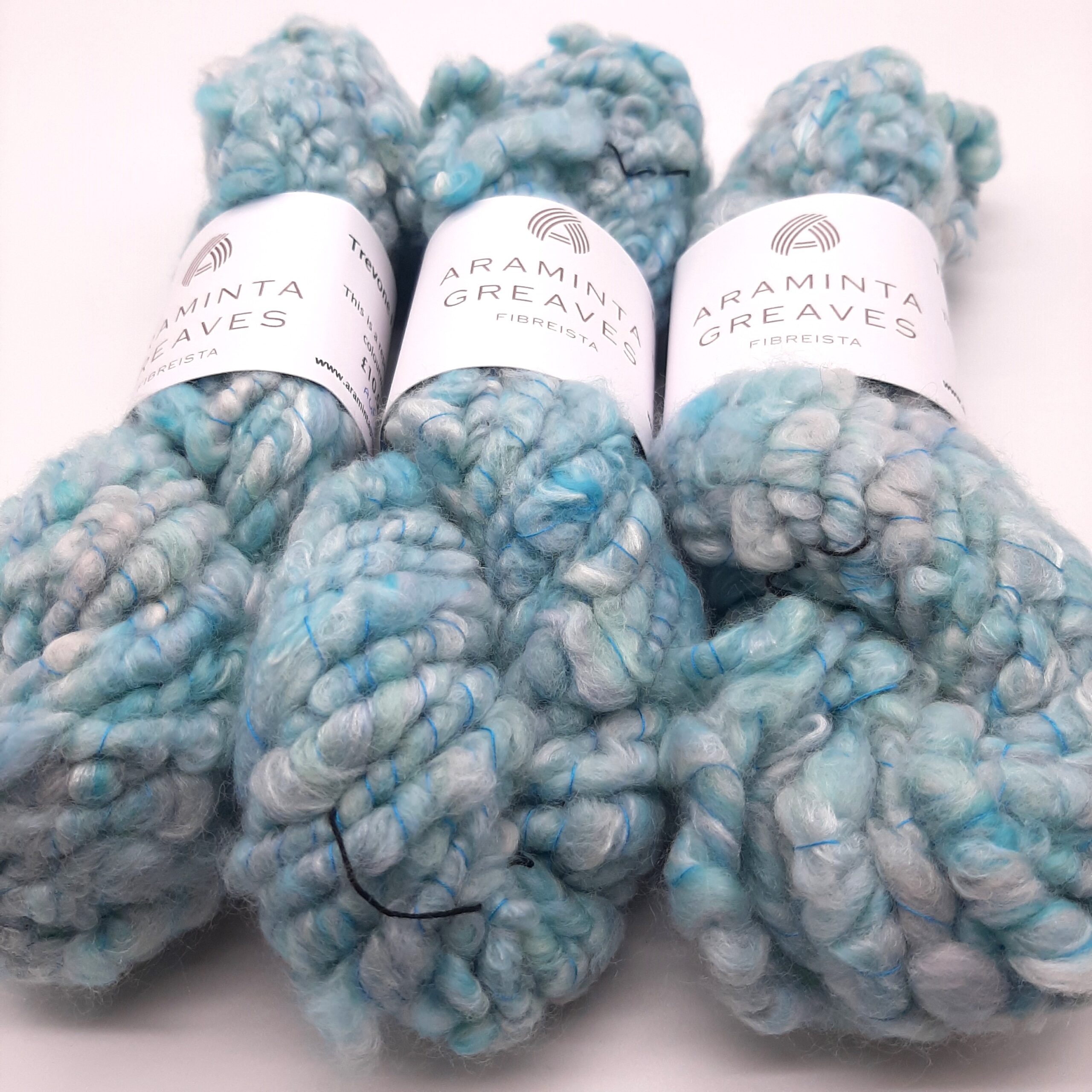Three skeins of Trevone Foam, handspun corespun merino and silk yarn in pale blue, turquoise and grey.