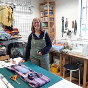 Rosie Green standing next to the work table on which my pink, purple and blue cloth is waiting to be cut.