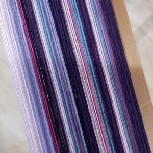 Close up of a warp made of shades of purple and pink cotton
