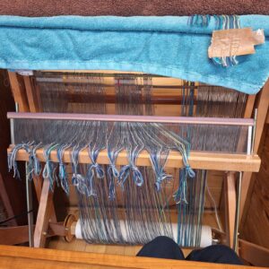 A Saori loom partly dressed with a warp in blues, lilacs and greens