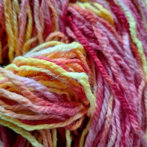 Close up of wool yarn hand dyed in pinks and yellows by Araminta Greaves Fibreista