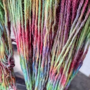Wool yarn, originally dyed pink and yellow, then over dyed with royal blue to create shades of greens, pinks, purples and blues